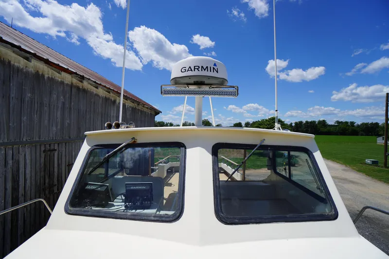 Slide: The Image of 1989 Markley 35 Ft. Deadrise boat with Garmin radar, docked near a wooden building. - 67