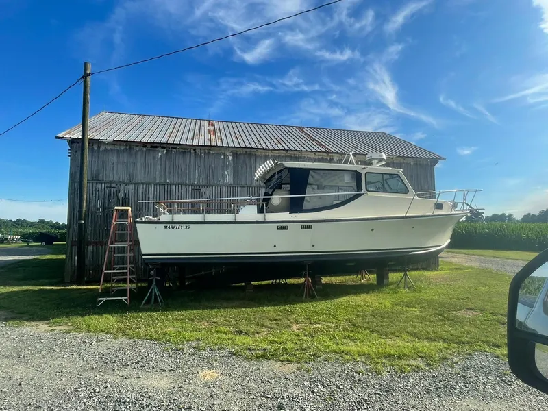 Slide: The Image of 1998 Markley 35 Ft. Deadrise boat on stands near a rustic barn. - 7