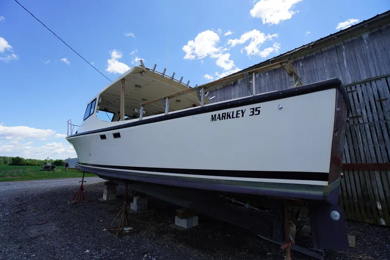 Slide: The Image of 1989 Markley 35 Ft. Deadrise boat on stands beside a wooden barn. - 74
