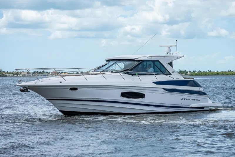 Slide: The Image of 2015 Regal 46 Sport Coupe yacht cruising on open water. - 14