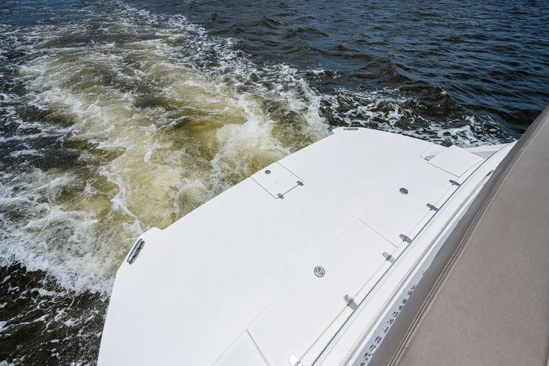 Slide: The Image of 2015 Regal 46 Sport Coupe boat cruising on water, rear view. - 21