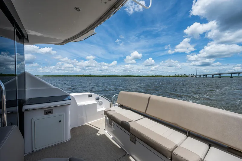 Slide: The Image of 2015 Regal 46 Sport Coupe boat with spacious deck and scenic water view. - 26