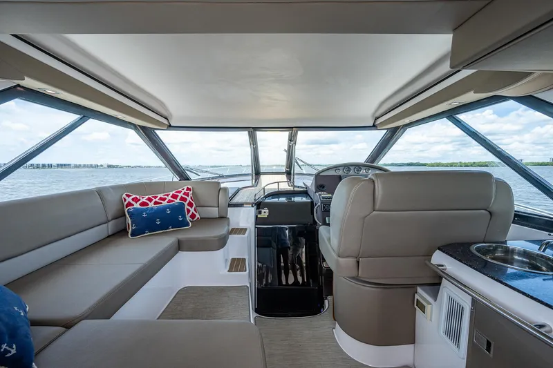 Slide: The Image of Interior of 2015 Regal 46 Sport Coupe yacht with plush seating and panoramic windows. - 29