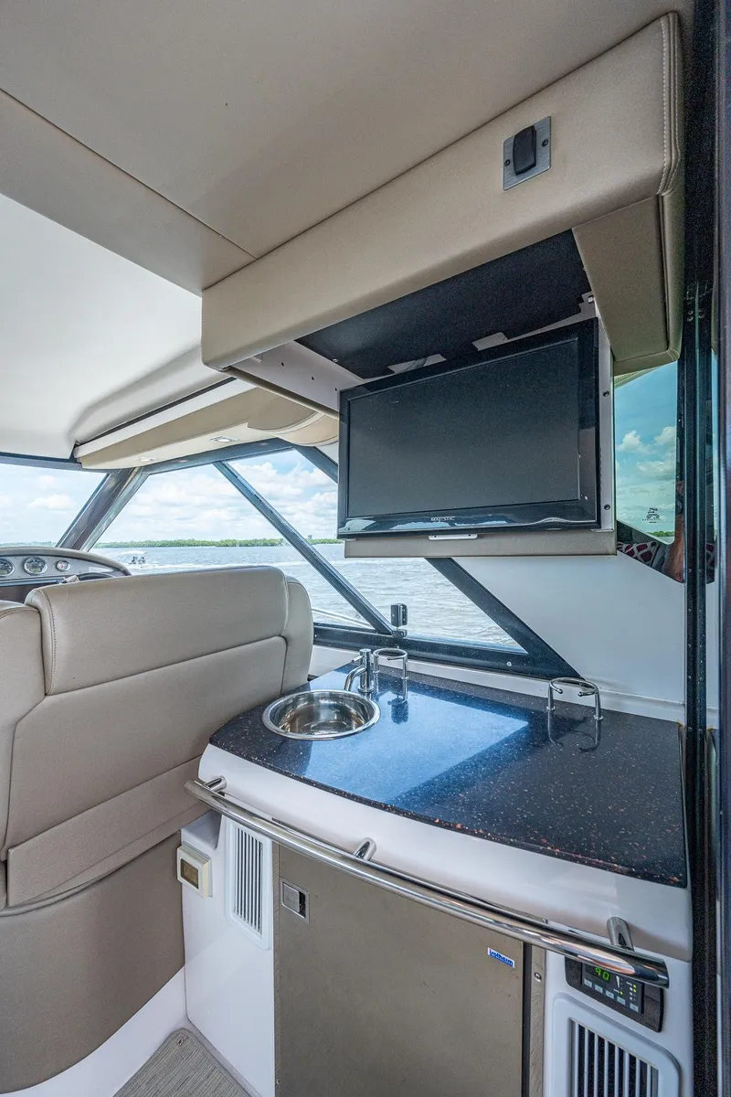 Slide: The Image of Interior of 2015 Regal 46 Sport Coupe with TV, sink, and seating. - 31