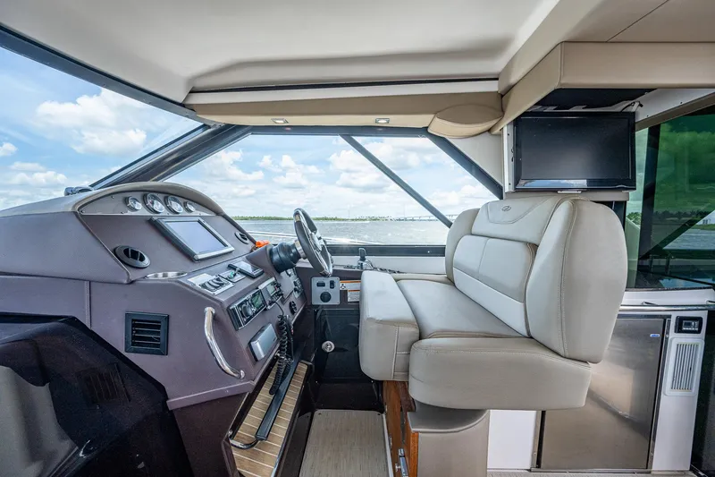 Slide: The Image of Interior cockpit of a 2015 Regal 46 Sport Coupe yacht with modern controls and seating. - 34