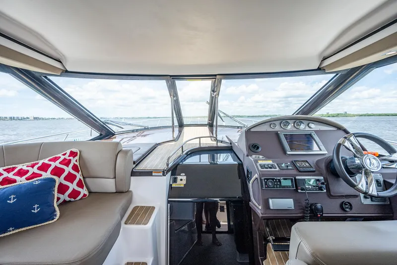 Slide: The Image of Interior of 2015 Regal 46 Sport Coupe yacht with helm and seating area. - 36
