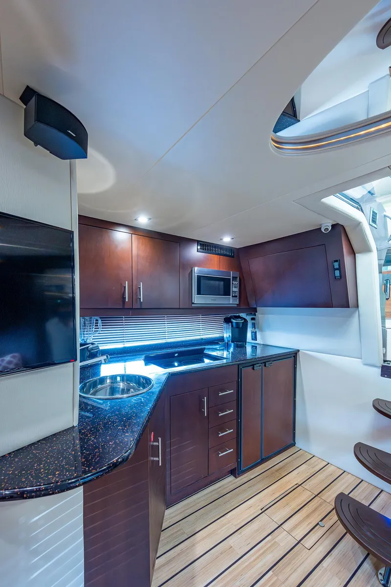 Slide: The Image of 2015 Regal 46 Sport Coupe yacht kitchen with modern appliances and wooden cabinetry. - 40