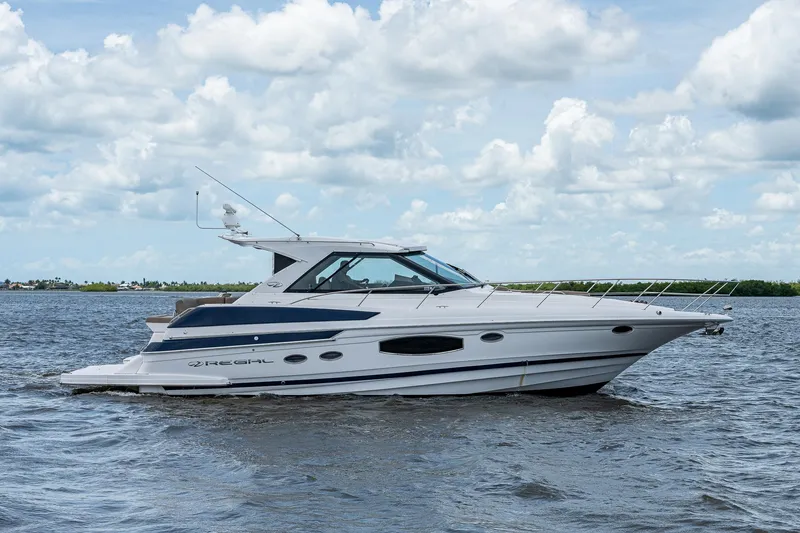 Slide: The Image of 2015 Regal 46 Sport Coupe yacht on open water under a cloudy sky. - 6