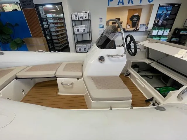 Slide: The Image of 2024 Northstar Axis 4.2 boat interior with seating and steering console in showroom. - 10