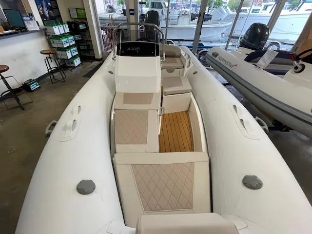 Slide: The Image of 2024 Northstar Axis 4.2 inflatable boat with beige seating and wooden flooring in showroom. - 3