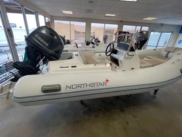 Slide: The Image of 2024 Northstar Axis 4.2 inflatable boat with Yamaha outboard motor in showroom. - 4