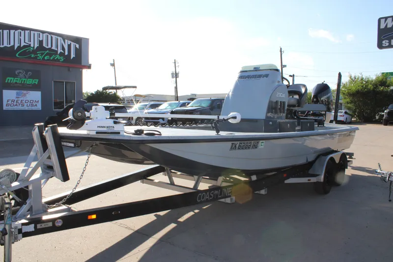 Slide: The Image of 2025 Mamba 23 Cat Classic boat on trailer outside dealership, featuring Minn Kota equipment. - 3