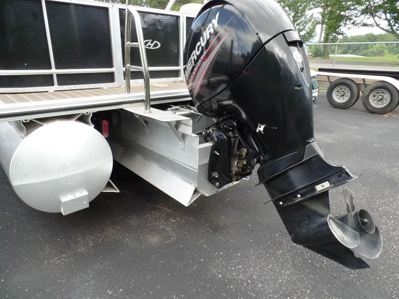 Slide: The Image of 2018 Harris Cruiser 240 pontoon boat with Mercury outboard motor, parked on asphalt. - 11