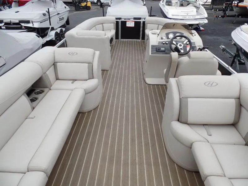 Slide: The Image of 2018 Harris Cruiser 240 pontoon boat interior with beige seating and wood-style flooring. - 2