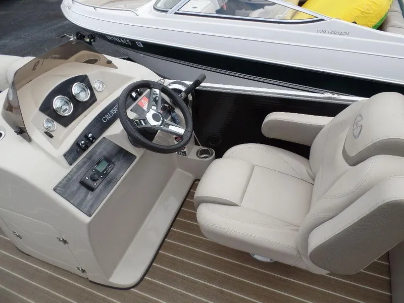 Slide: The Image of 2018 Harris Cruiser 240 boat interior with steering wheel and beige captain's chair. - 5