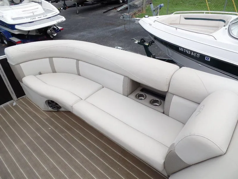 Slide: The Image of 2018 Harris Cruiser 240 boat interior with beige seating and cup holders. - 8