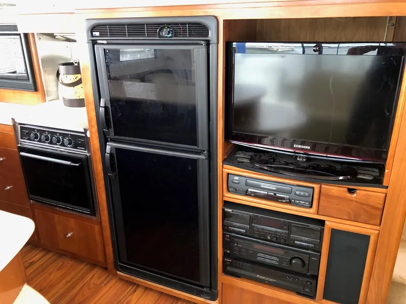 Slide: The Image of 1998 Carver 530 Voyager Pilothouse interior with kitchen appliances and entertainment system. - 12