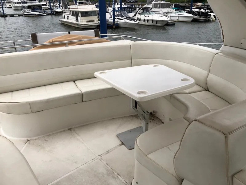 Slide: The Image of 1998 Carver 530 Voyager Pilothouse yacht interior seating area with table at marina. - 19