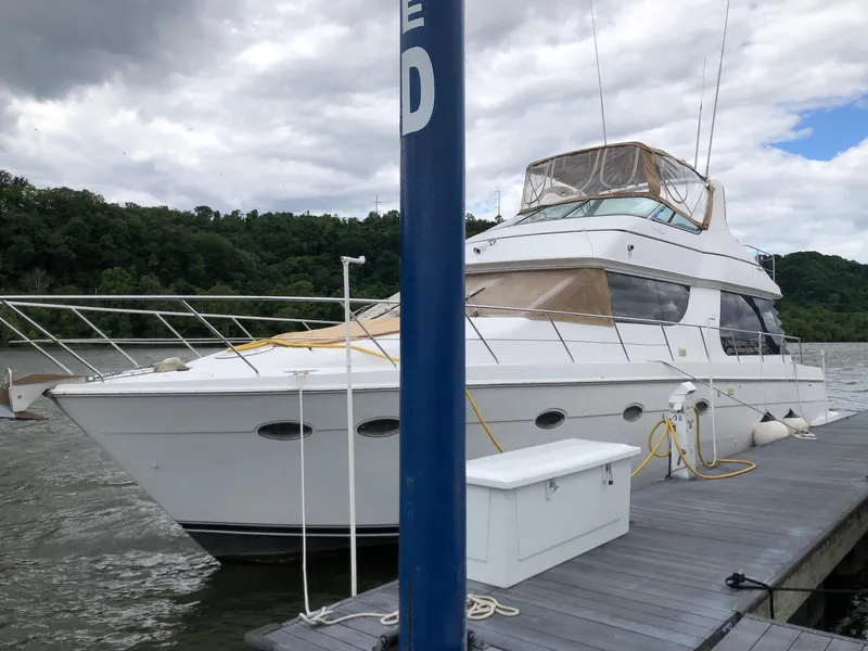 The Image of 1998 Carver 530 Voyager Pilothouse yacht docked at a marina. - 1