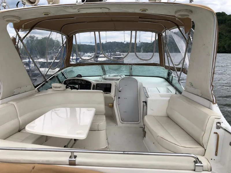 Slide: The Image of 1998 Carver 530 Voyager Pilothouse interior with seating and table, docked on a lake. - 15