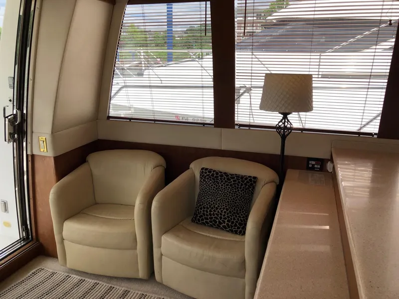 Slide: The Image of Interior of 1998 Carver 530 Voyager Pilothouse with beige chairs and lamp. - 8