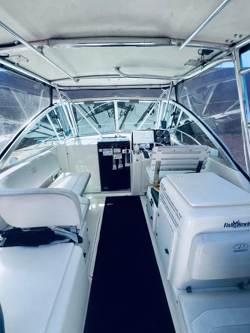 Slide: The Image of 2002 Pursuit 3000 Express boat interior with helm, seating, and navigation equipment. - 10