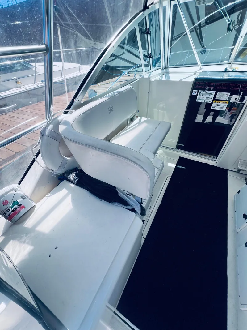 Slide: The Image of 2002 Pursuit 3000 Express boat interior with white seating and control panel. - 11