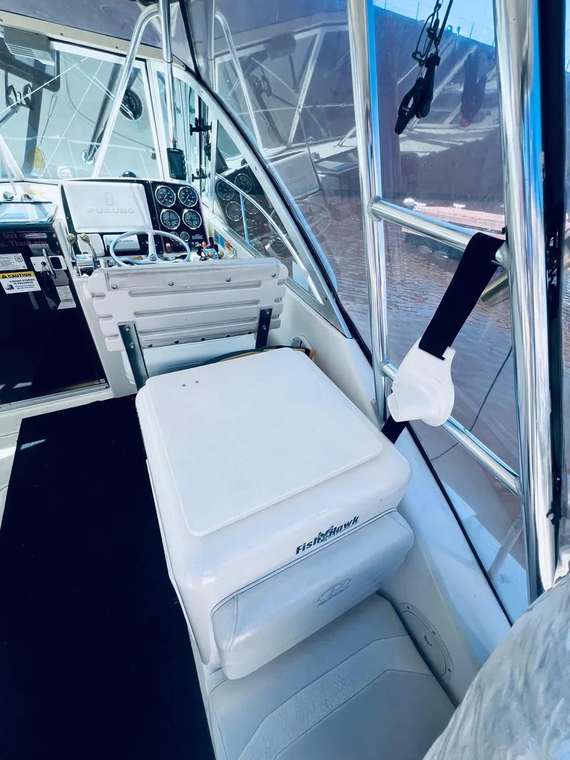 Slide: The Image of 2002 Pursuit 3000 Express boat interior with helm and seating area. - 12