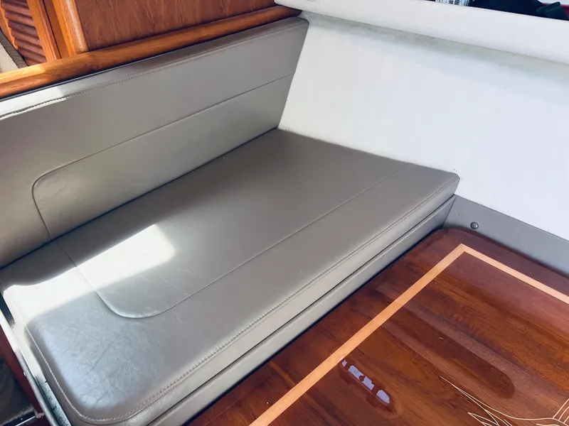 Slide: The Image of 2002 Pursuit 3000 Express interior with gray leather seating and polished wooden table. - 17