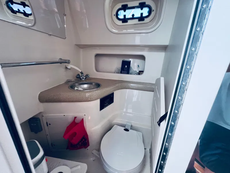 Slide: The Image of 2002 Pursuit 3000 Express boat bathroom with sink, toilet, and storage. - 18