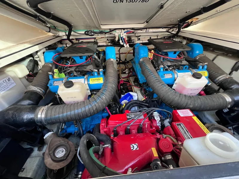 Slide: The Image of Engine compartment of a 2002 Pursuit 3000 Express boat, featuring dual blue engines. - 19