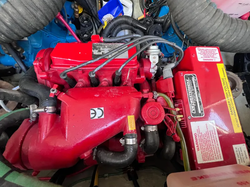 Slide: The Image of Engine compartment of a 2002 Pursuit 3000 Express boat, featuring a red engine and components. - 20