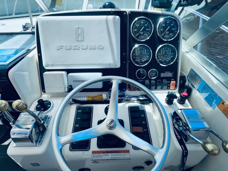 Slide: The Image of Control panel of a 2002 Pursuit 3000 Express boat with steering wheel and gauges. - 9