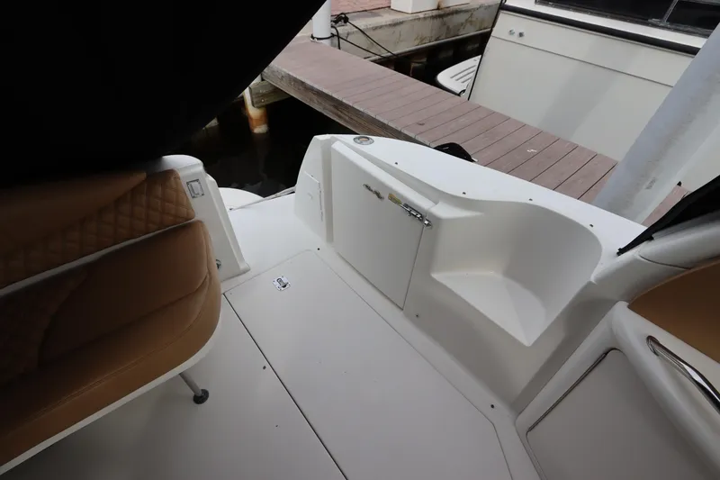 Slide: The Image of 1999 Sea Ray 380 Sundancer boat interior with tan seating and dock view. - 10