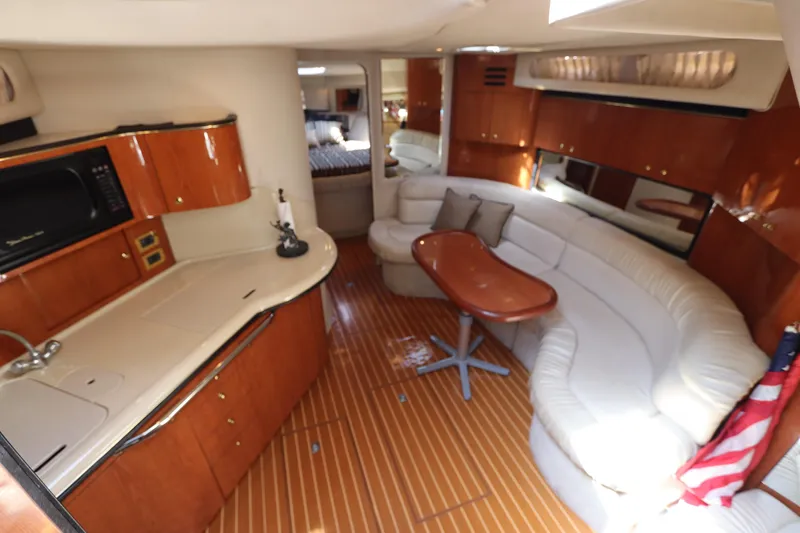 Slide: The Image of Interior of 1999 Sea Ray 380 Sundancer yacht with kitchen and seating area. - 23