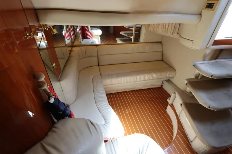 Slide: The Image of Interior of 1999 Sea Ray 380 Sundancer with beige seating and wooden flooring. - 24