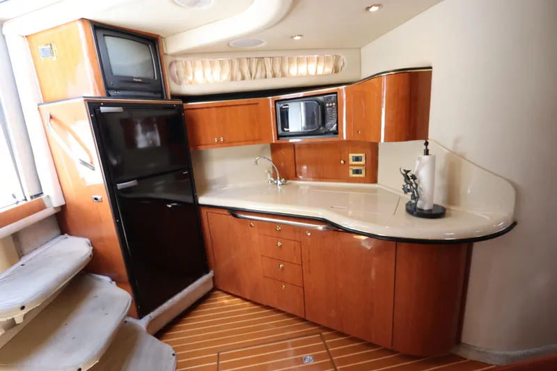 Slide: The Image of 1999 Sea Ray 380 Sundancer yacht kitchen with wood cabinetry and modern appliances. - 25
