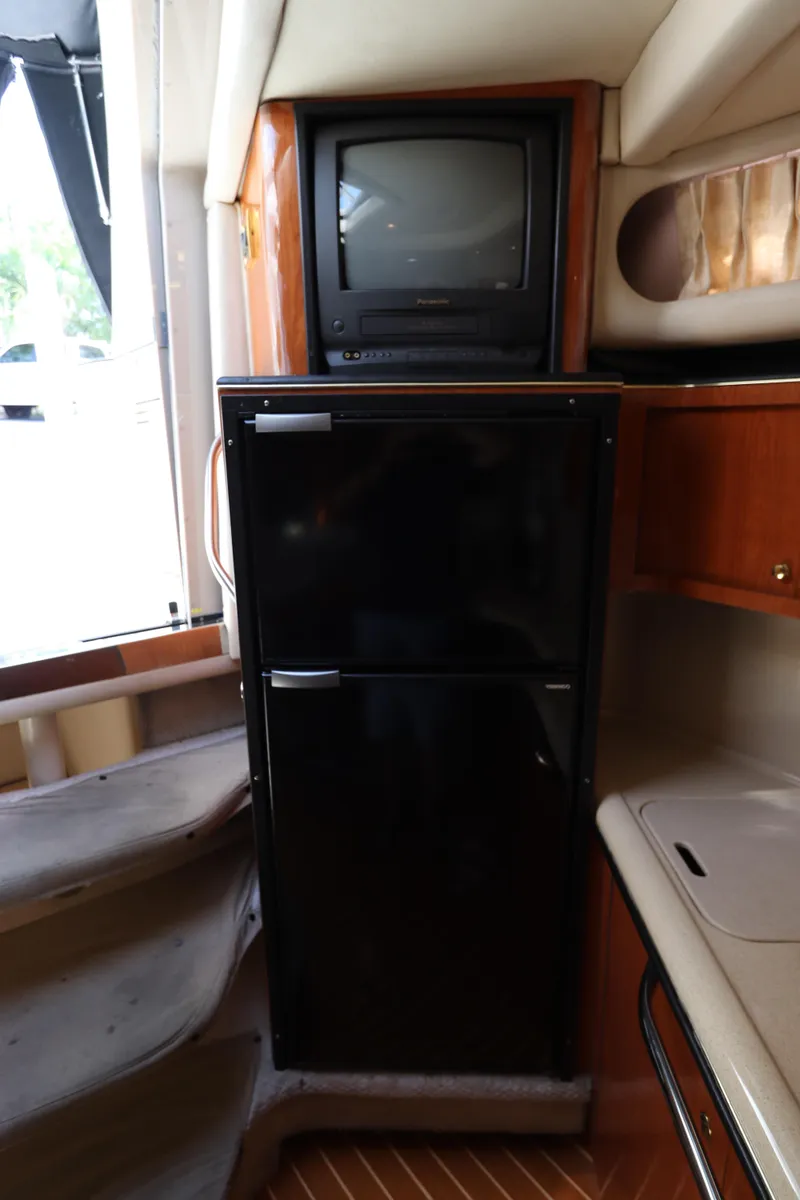 Slide: The Image of 1999 Sea Ray 380 Sundancer interior with TV and refrigerator - 26
