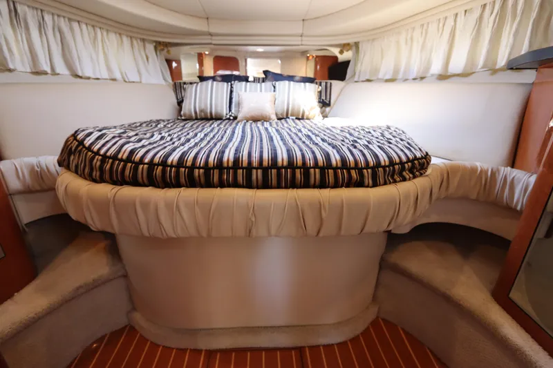 Slide: The Image of Interior cabin of 1999 Sea Ray 380 Sundancer with striped bedding and cozy decor. - 31