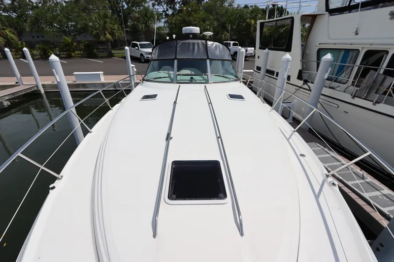 Slide: The Image of 1999 Sea Ray 380 Sundancer docked, front deck view with hatch and railings. - 5