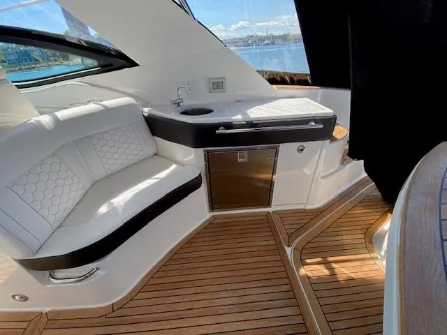 Slide: The Image of Interior of 2022 Sea Ray 320 Sundancer Outboard with seating and kitchenette. - 13