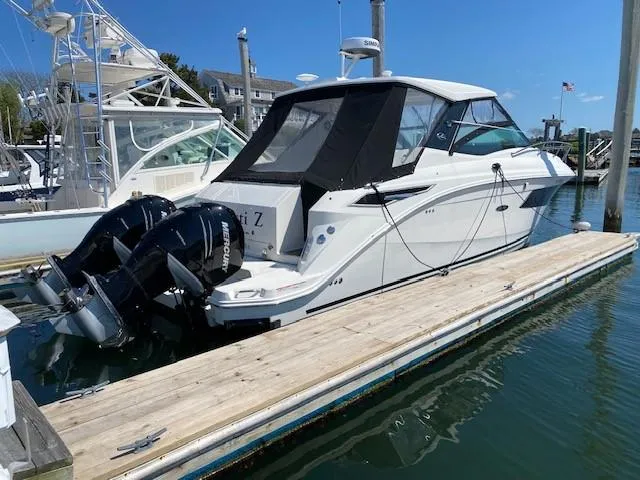 Slide: The Image of 2022 Sea Ray 320 Sundancer Outboard docked at a marina. - 2