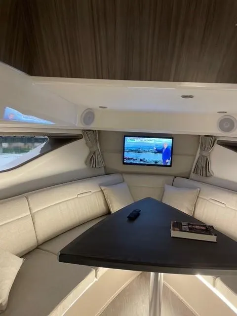 Slide: The Image of Interior of 2022 Sea Ray 320 Sundancer Outboard with cozy seating and TV. - 4