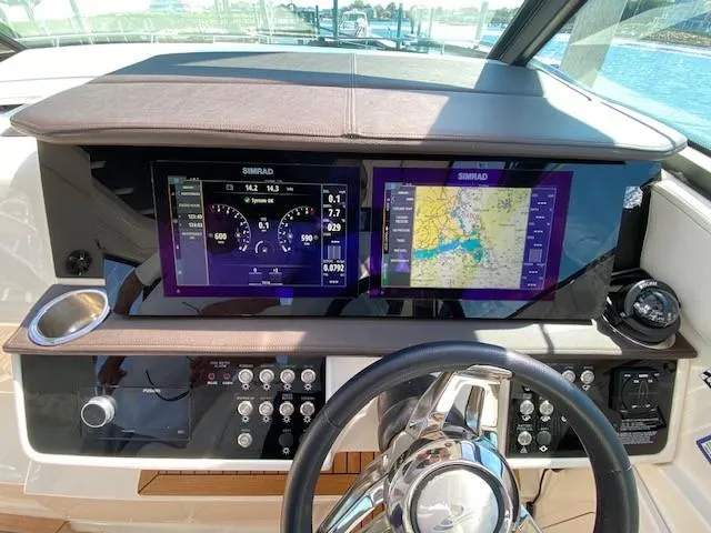 Slide: The Image of 2022 Sea Ray 320 Sundancer Outboard helm with dual Simrad displays and navigation controls. - 5
