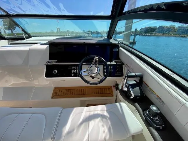 Slide: The Image of 2022 Sea Ray 320 Sundancer Outboard helm with modern controls and waterfront view. - 6