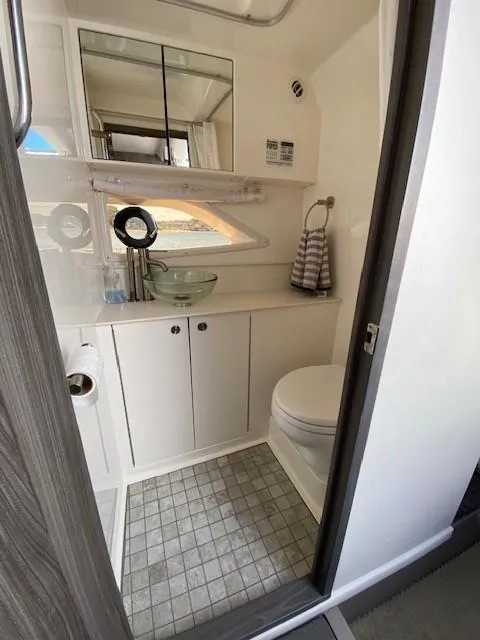 Slide: The Image of 2022 Sea Ray 320 Sundancer Outboard bathroom with modern fixtures and ample storage. - 8