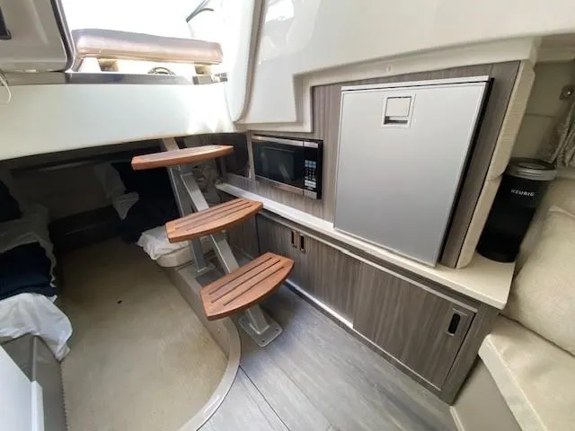 Slide: The Image of Interior cabin of 2022 Sea Ray 320 Sundancer Outboard with wooden steps, microwave, and mini-fridge. - 9