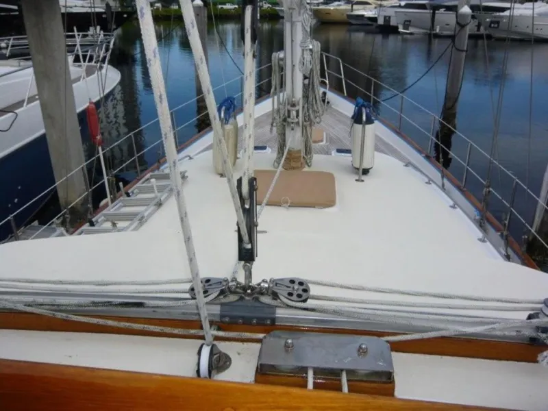Slide: The Image of 1990 Cheoy Lee Sloop deck view with rigging and marina background. - 20