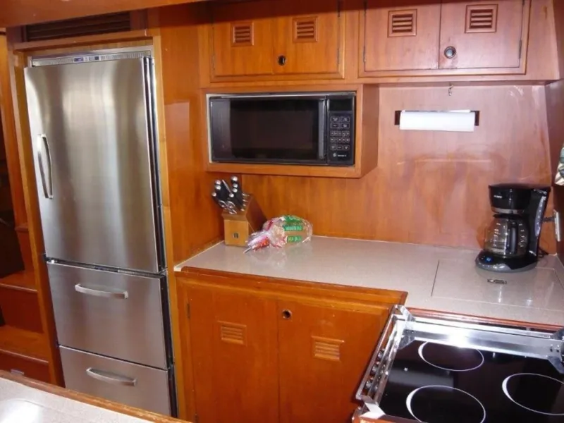 Slide: The Image of Cheoy Lee 1990 Sloop kitchen with stainless steel appliances and wooden cabinetry. - 42