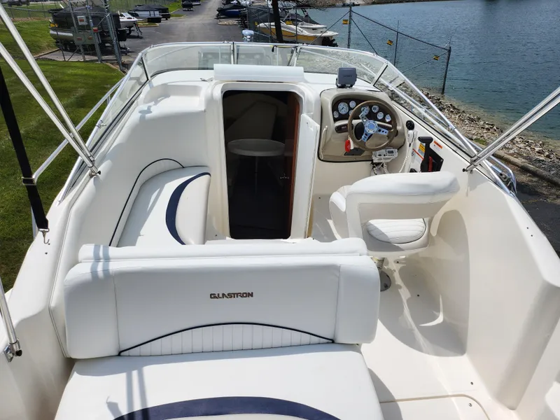 Slide: The Image of 2008 Glastron GT 249 boat interior with white seating and control panel. - 10